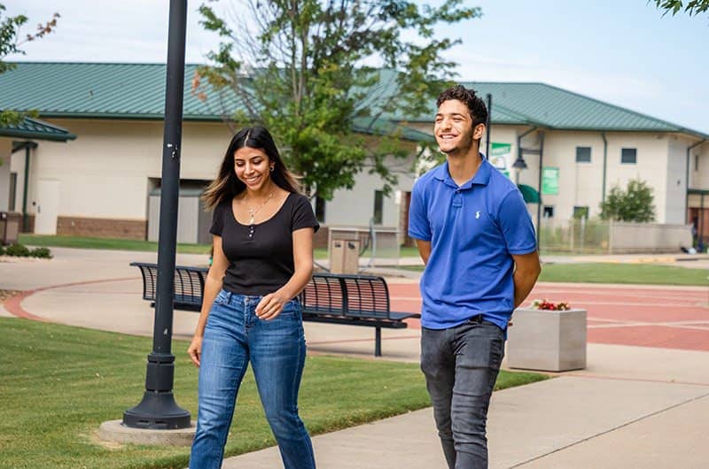 Photo of two students walking together Photo of two students walking together