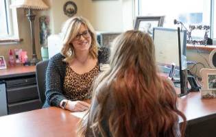 A Woman Sitting Across From Another Woman at a Desk A Woman Sitting Across From Another Woman at a Desk