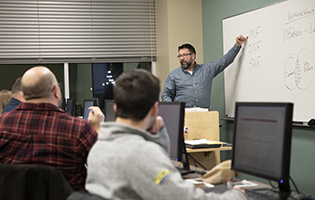 Teacher Pointing to Board In Front of a Class Teacher Pointing to Board In Front of a Class