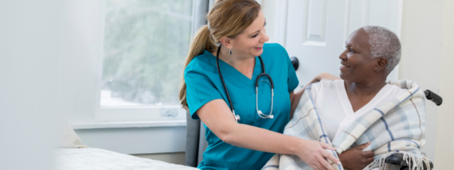 Female CNA Assisting a Female Patient in Wheelchair Female CNA Assisting a Female Patient in Wheelchair