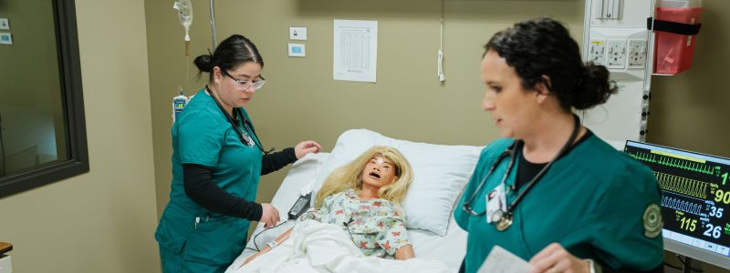 Female 护理 Students Beside a Patient