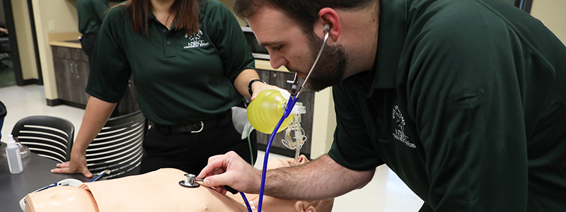 Male Student Using a Stethoscope on a Dummy Male Student Using a Stethoscope on a Dummy