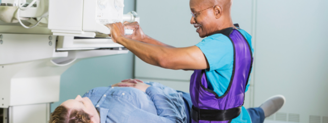 Man Lowering Imaging Machine onto Female Patient