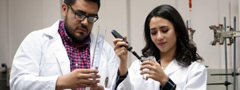 Man and Woman Filling Beakers with a Solution