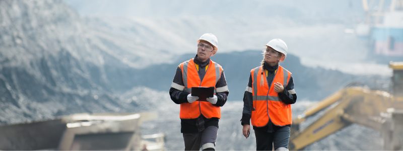 Two People in Construction Outfits Walking Around a Site in the Mountains Two People in Construction Outfits Walking Around a Site in the Mountains