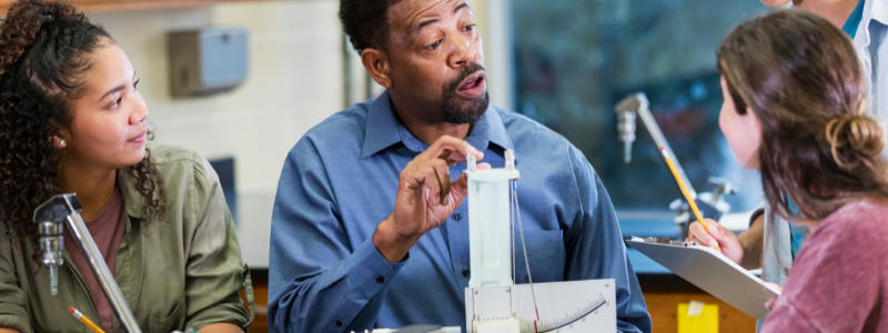 Teacher and Students Around Devices on Table Teacher and Students Around Devices on Table