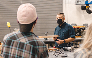 3D Design Class Man wearing mask teaches students about lumber