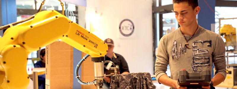 A robotics student programming a robot A robotics student programming a robot