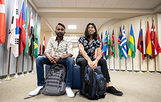 Two Students Sitting and Surrounded by Flags Two Students Sitting and Surrounded by Flags