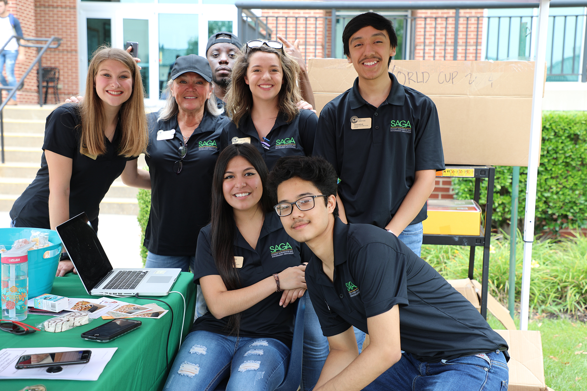 Group of student ambasadors smiling for the camera while under a tent at an event Group of student ambasadors smiling for the camera while under a tent at an event