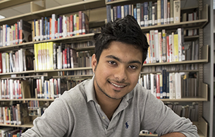 Young Hispanic male student smiling in the library Young Hispanic male student smiling in the library