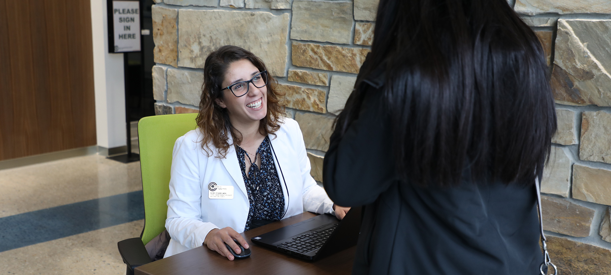 A Woman Sitting at a Table and Smiling A Woman Sitting at a Table and Smiling